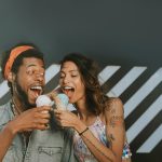 A man and a women about to bite ice cream