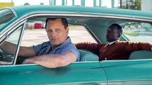 Cover of the movie Green book. Two men sitting in a turquoise chevy from the 1960´s, the driver is a white man and in the backseat sits an afrikan man.